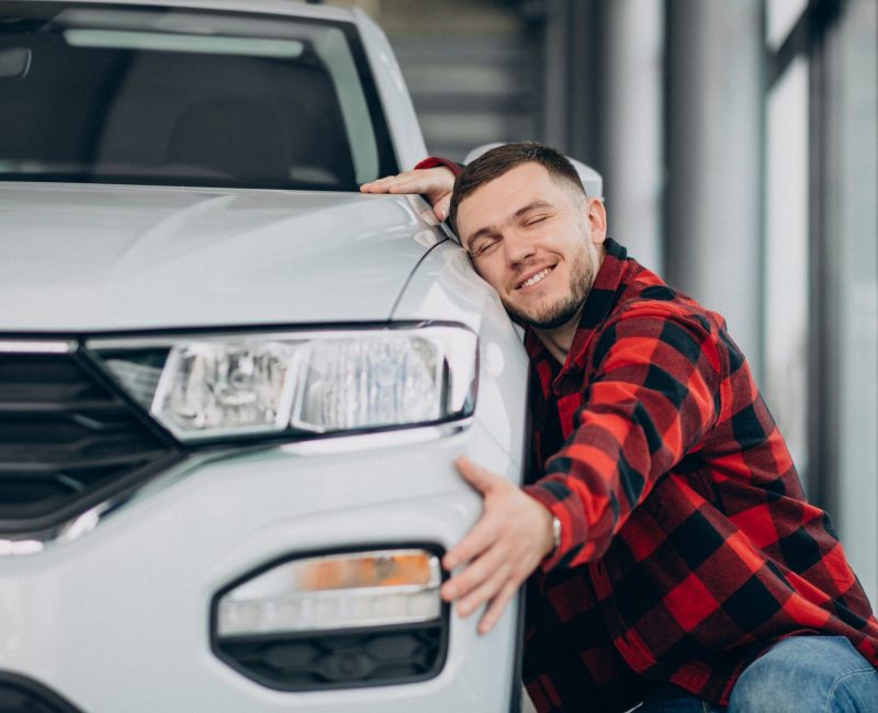 young-man-choosing-car-car-showroom-min